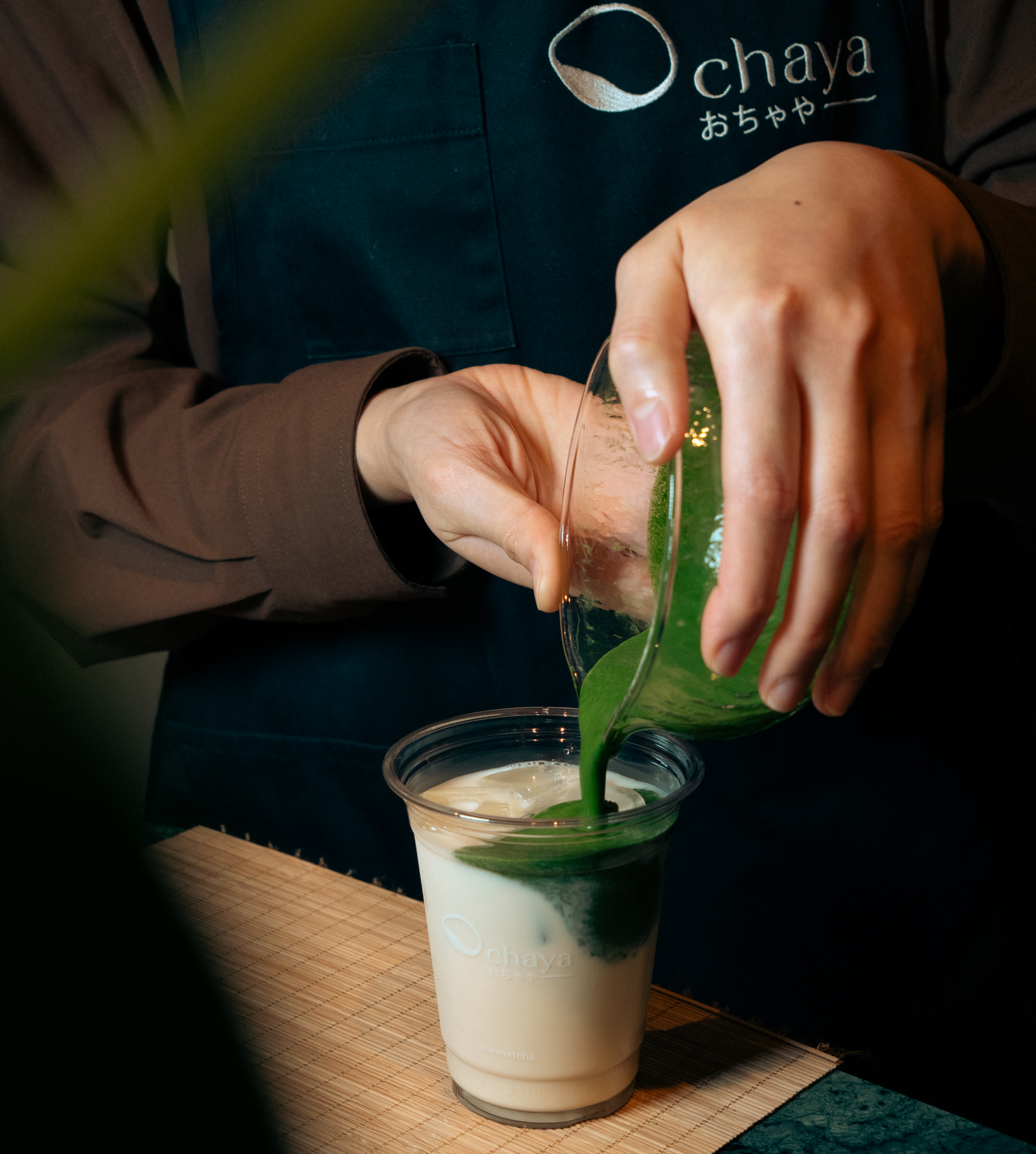Person pouring matcha into a cup